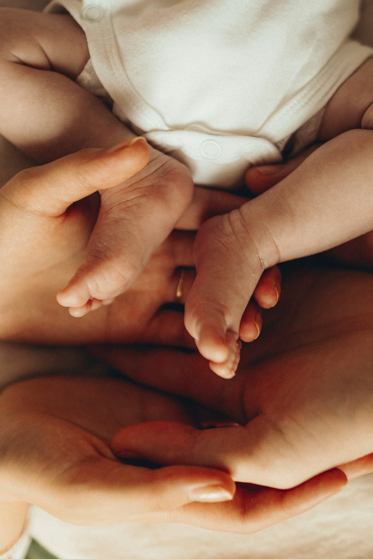 Mani di genitori che accolgono i piedi di un neonato