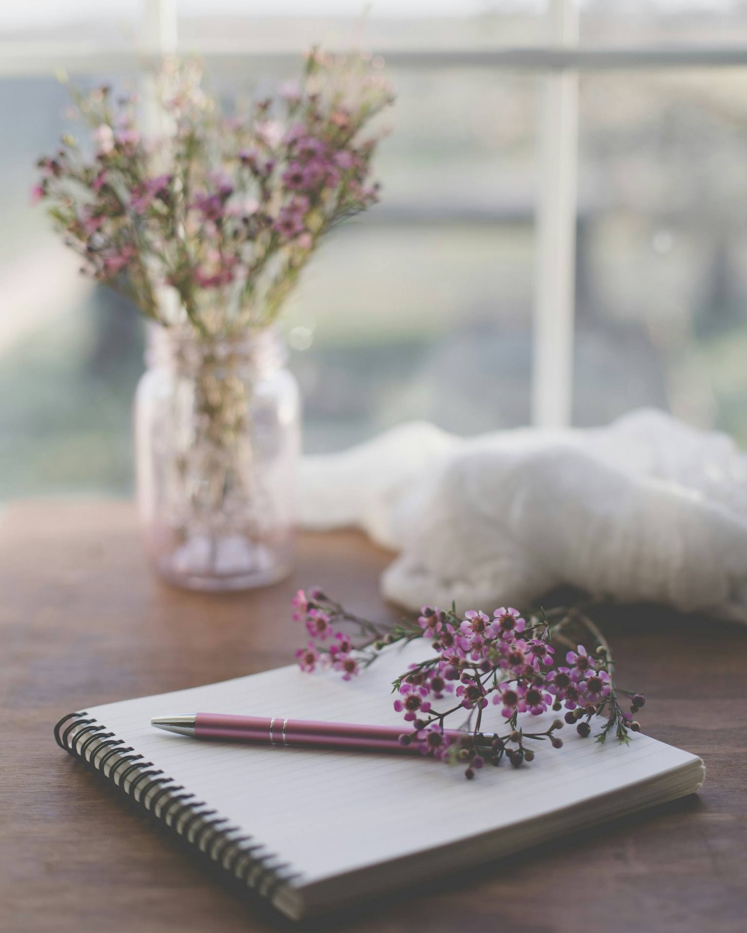 Quaderno e fiori per annotare i segnali del ciclo